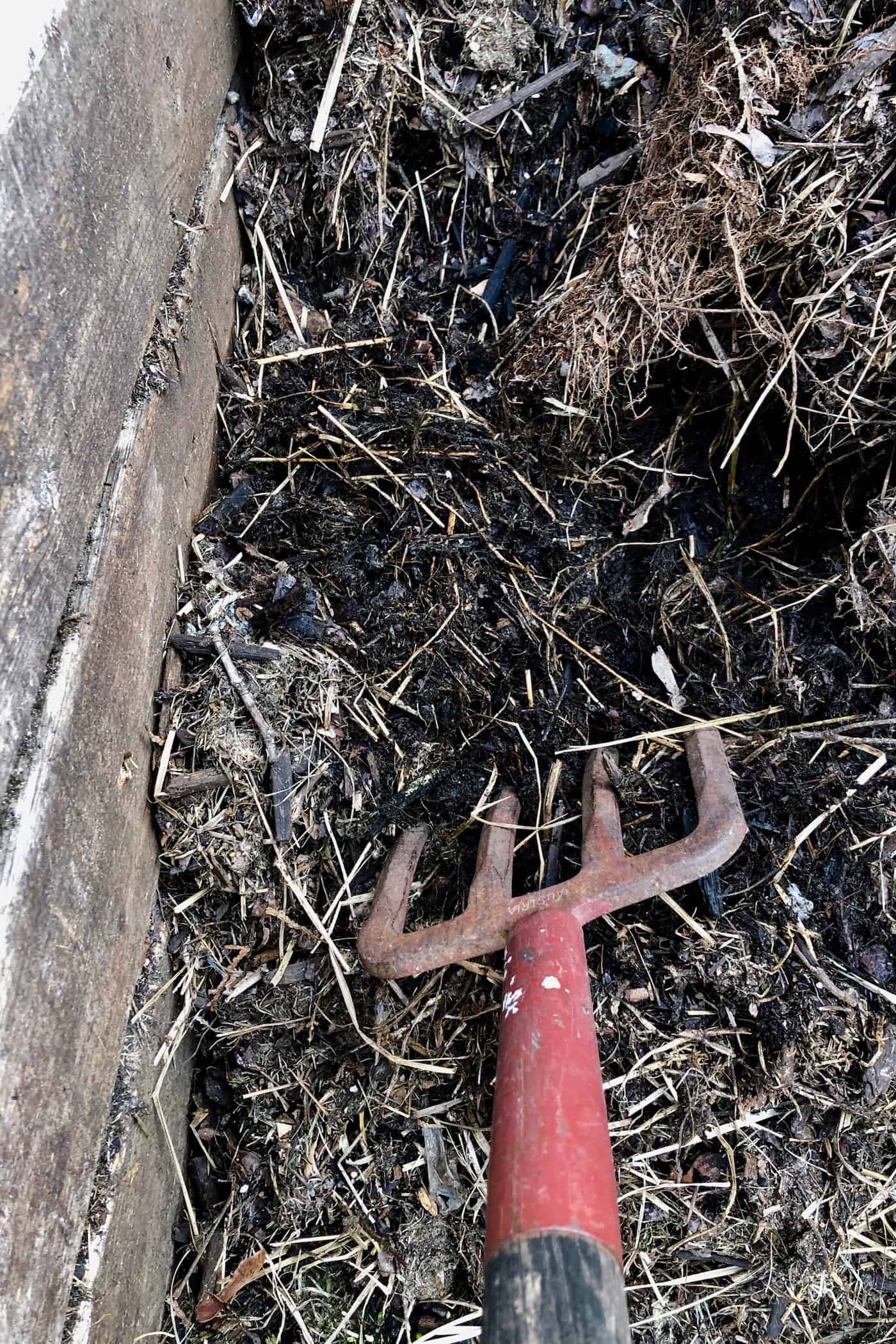 Pitchfork turning compost heap