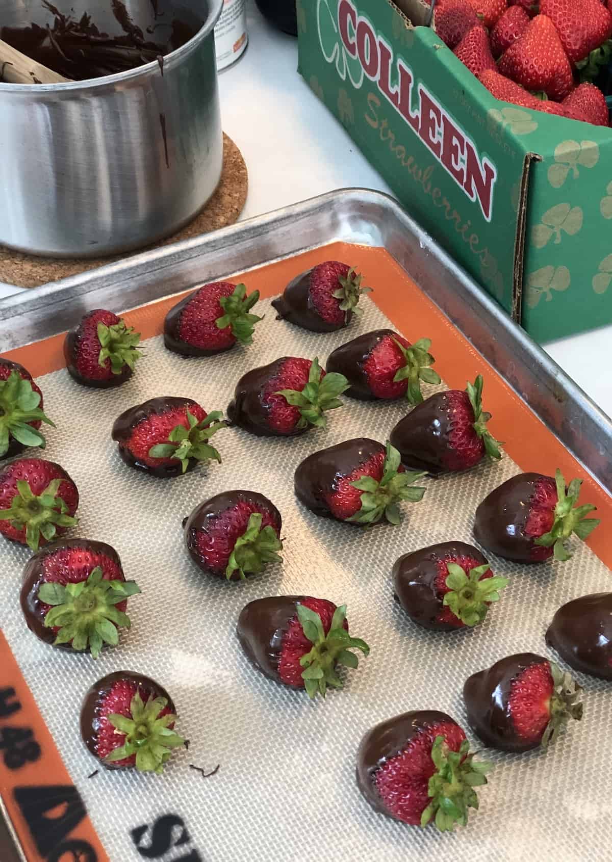 Dipping fresh strawberries in chocolate in june