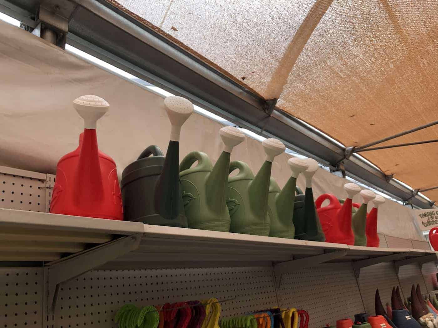 green plastic watering cans on store shelf