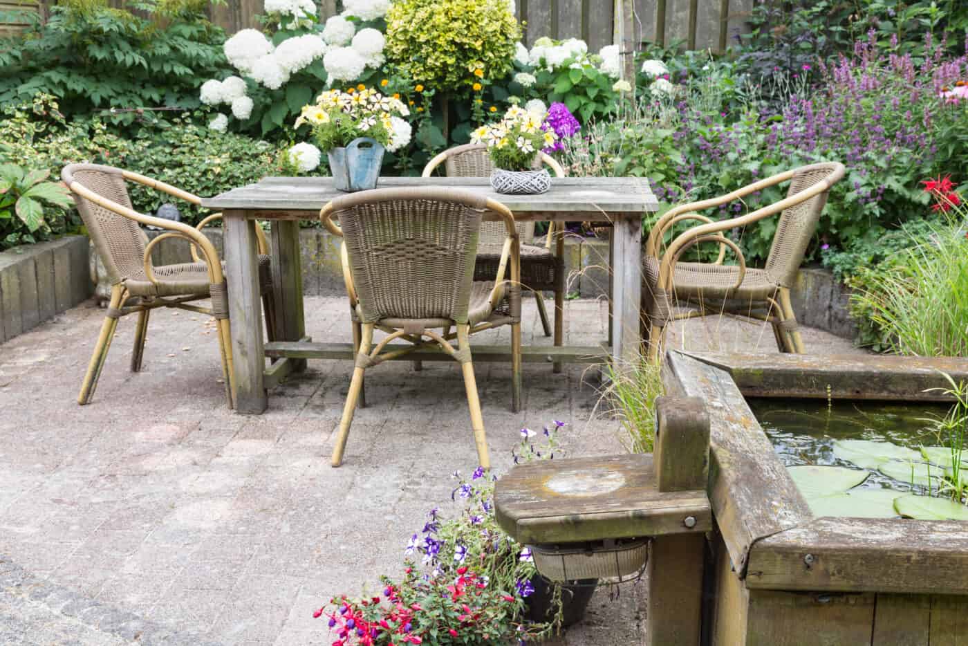 Wooden table and chairs in an ornamental garden with pond